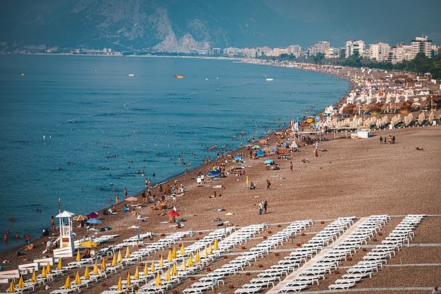 A beach with people enjoying and a body of water in the background. Antalya, Turkey.