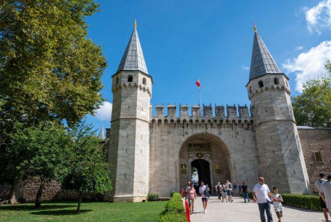 a group of people walking outside of a castle with topkapi castle in the background - Turkey's 15 Best Historical Sites