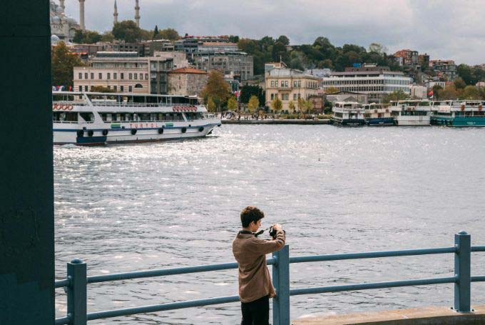 Young Tourist Photographing Bosphorus Waterside - Best Things To Do On the Asian Side of Istanbul