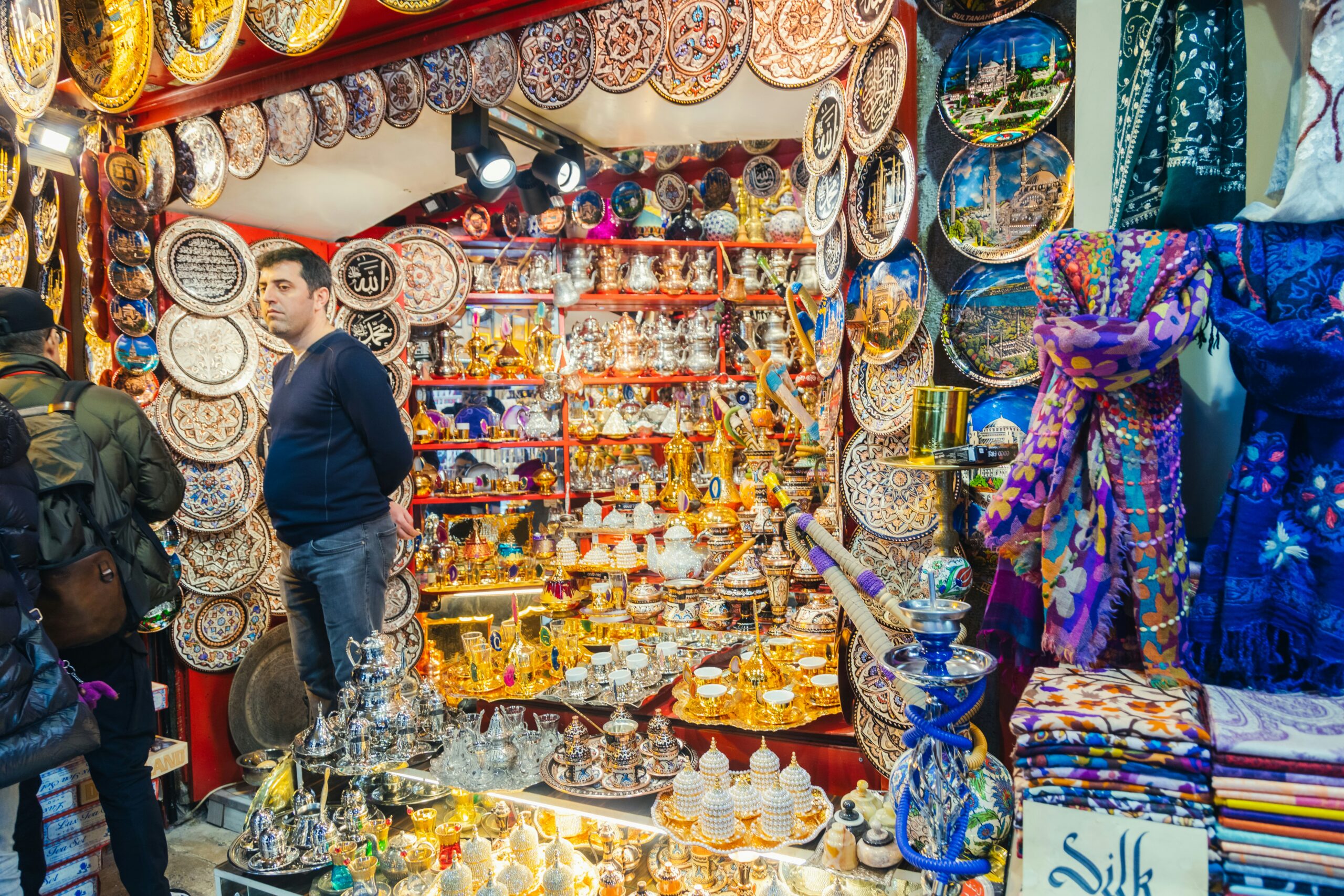 A shop with people standing infront of it. Shop selling Turkish utensils for tea and coffee at Turkish bazaar in Turkey.