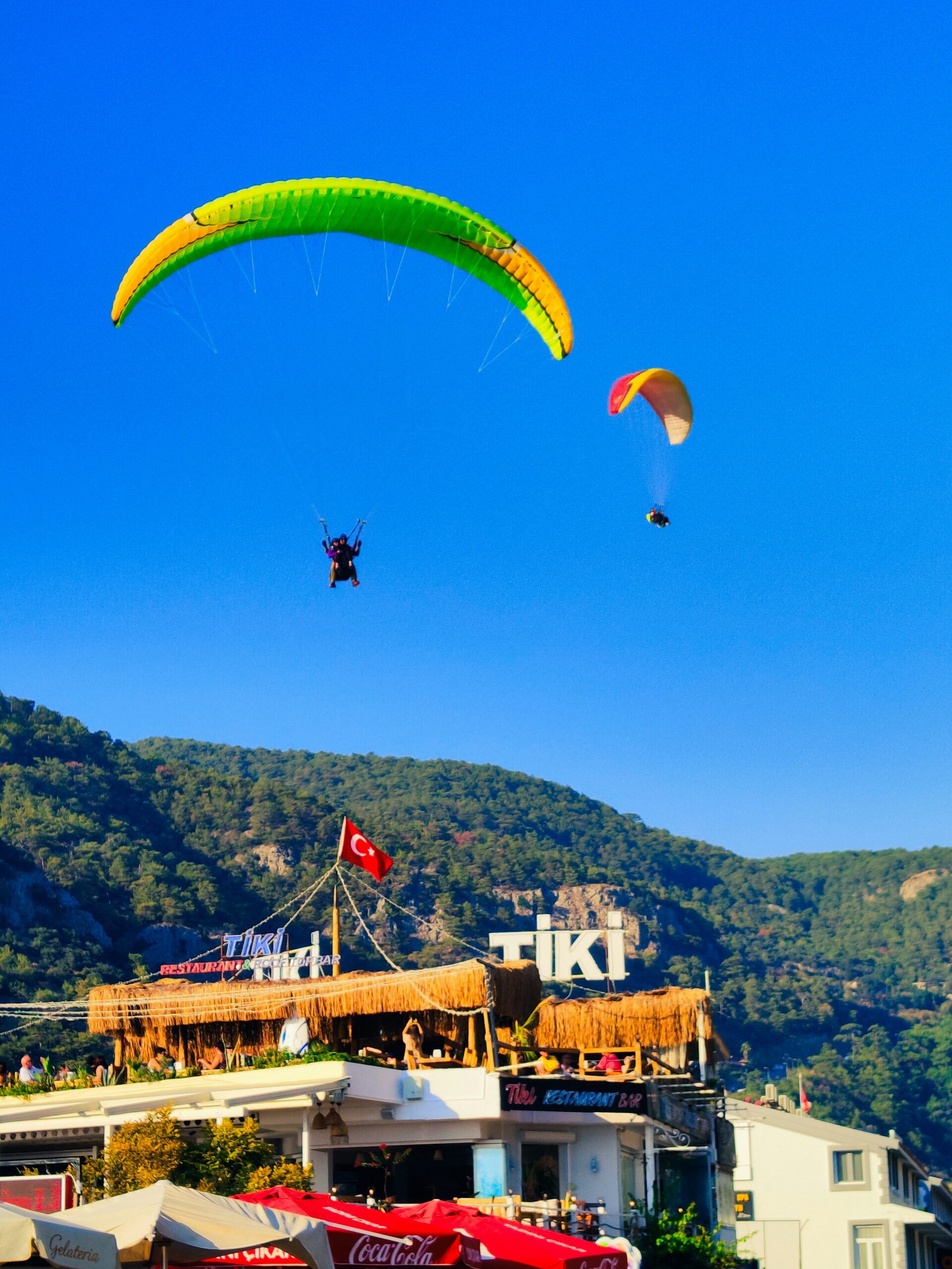 Groups of people paragliding  over a city.