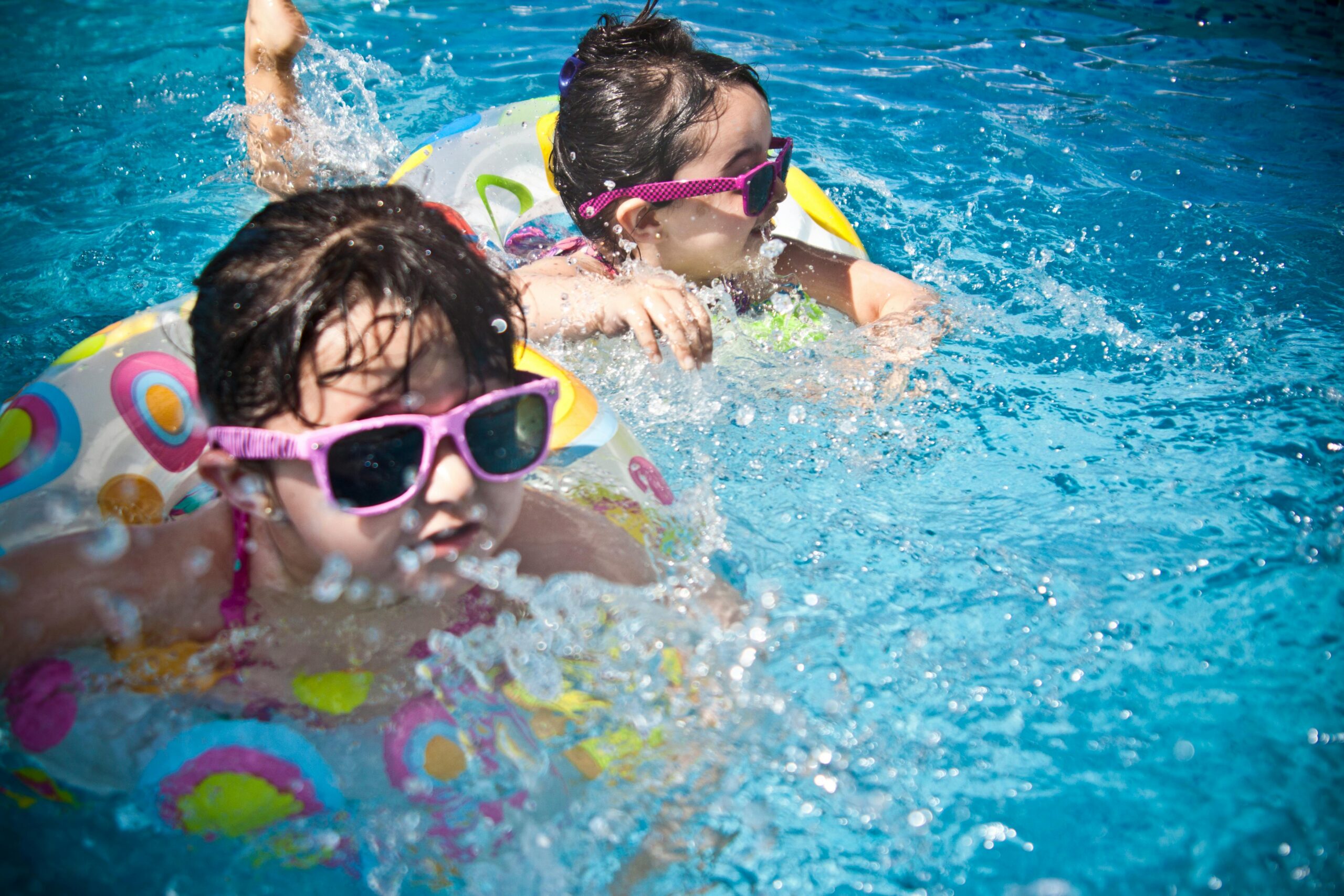 2 girls swimming during daytime