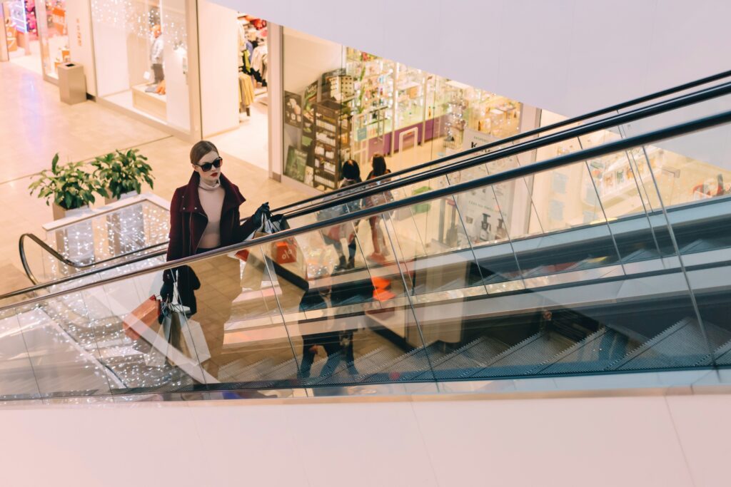 a woman on an escalator located in a shopping mall