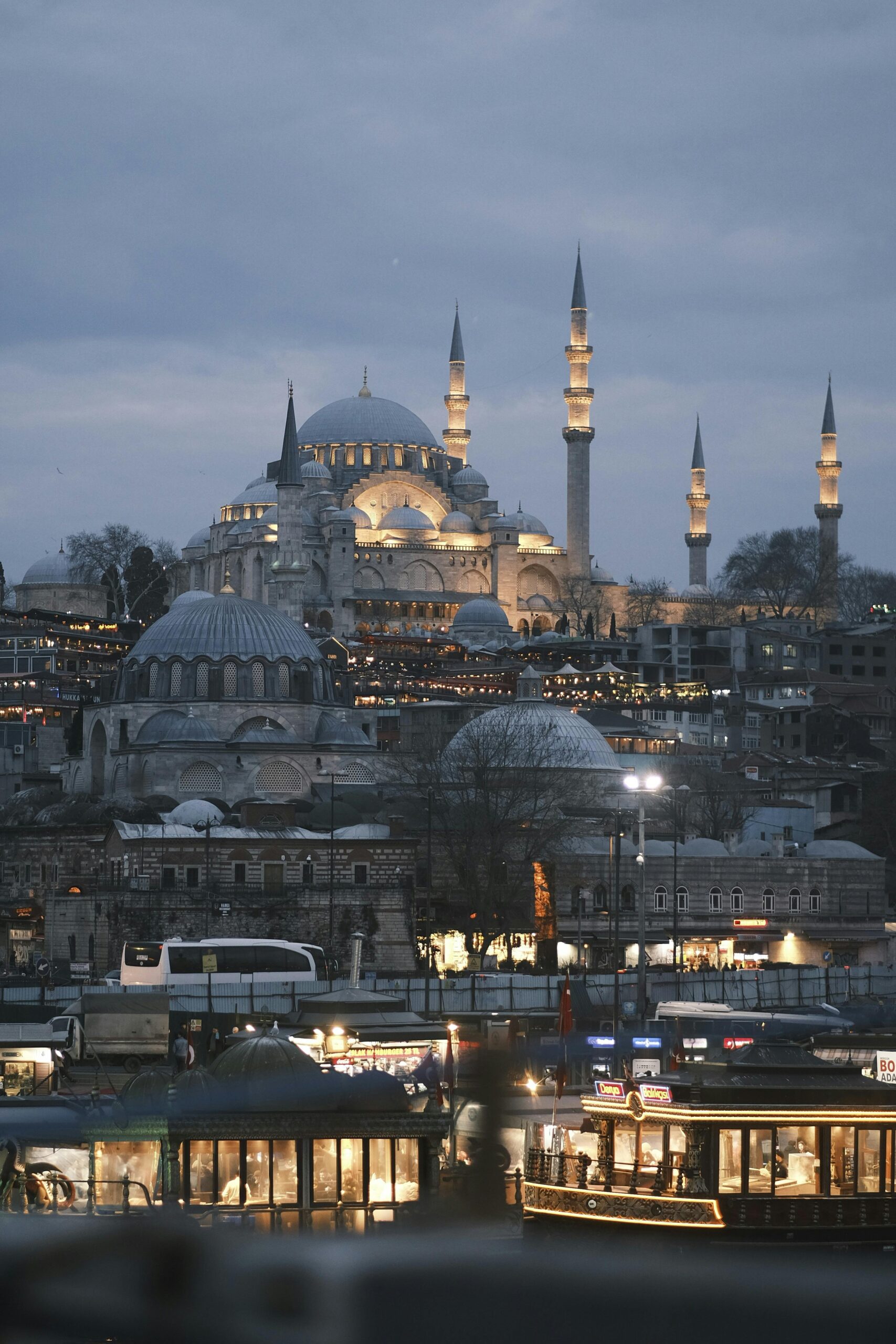 Illuminated mosque and city buildings.